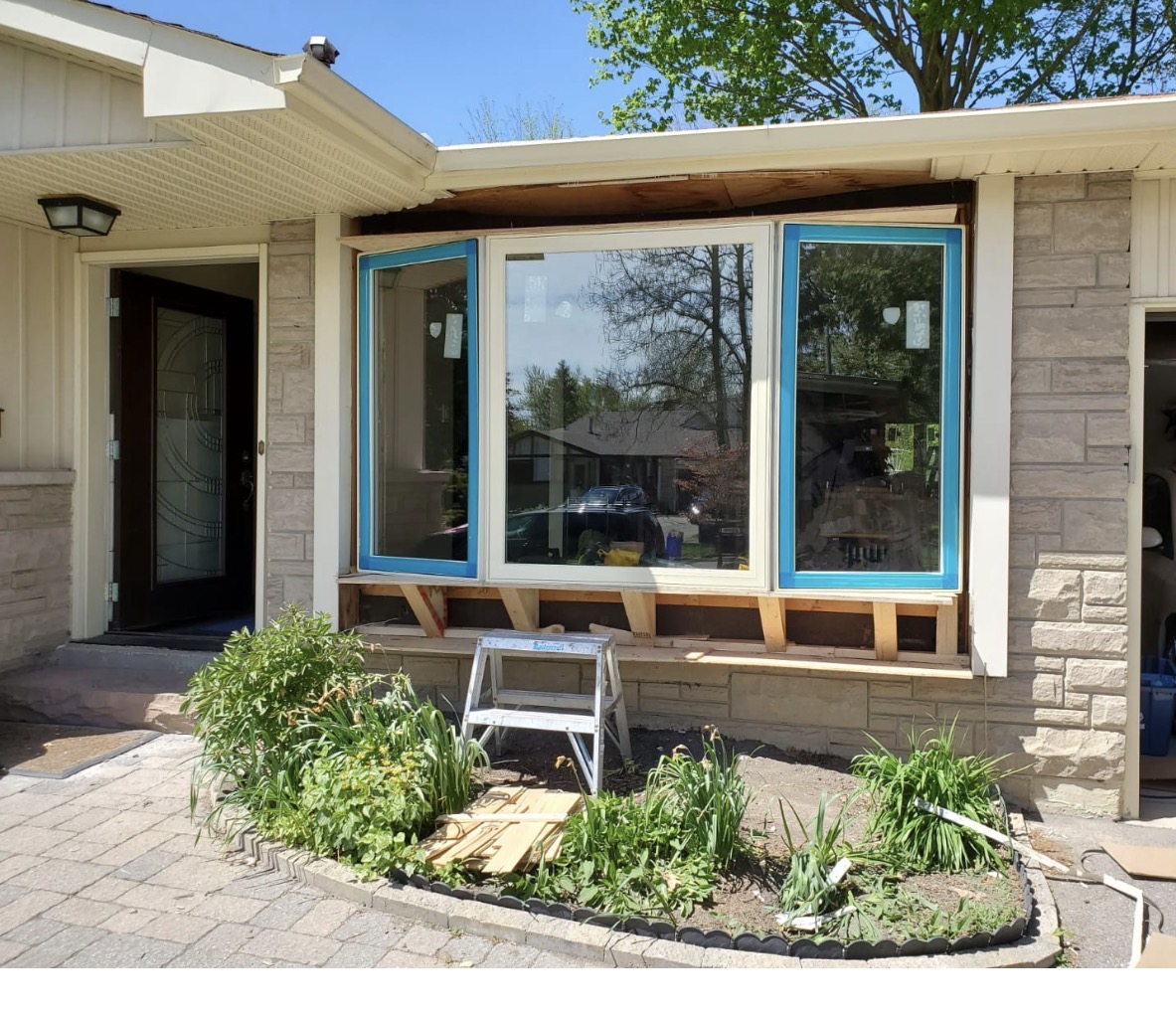 New three-panel bay window installed on a Barrie home with framing exposed below and fresh header above