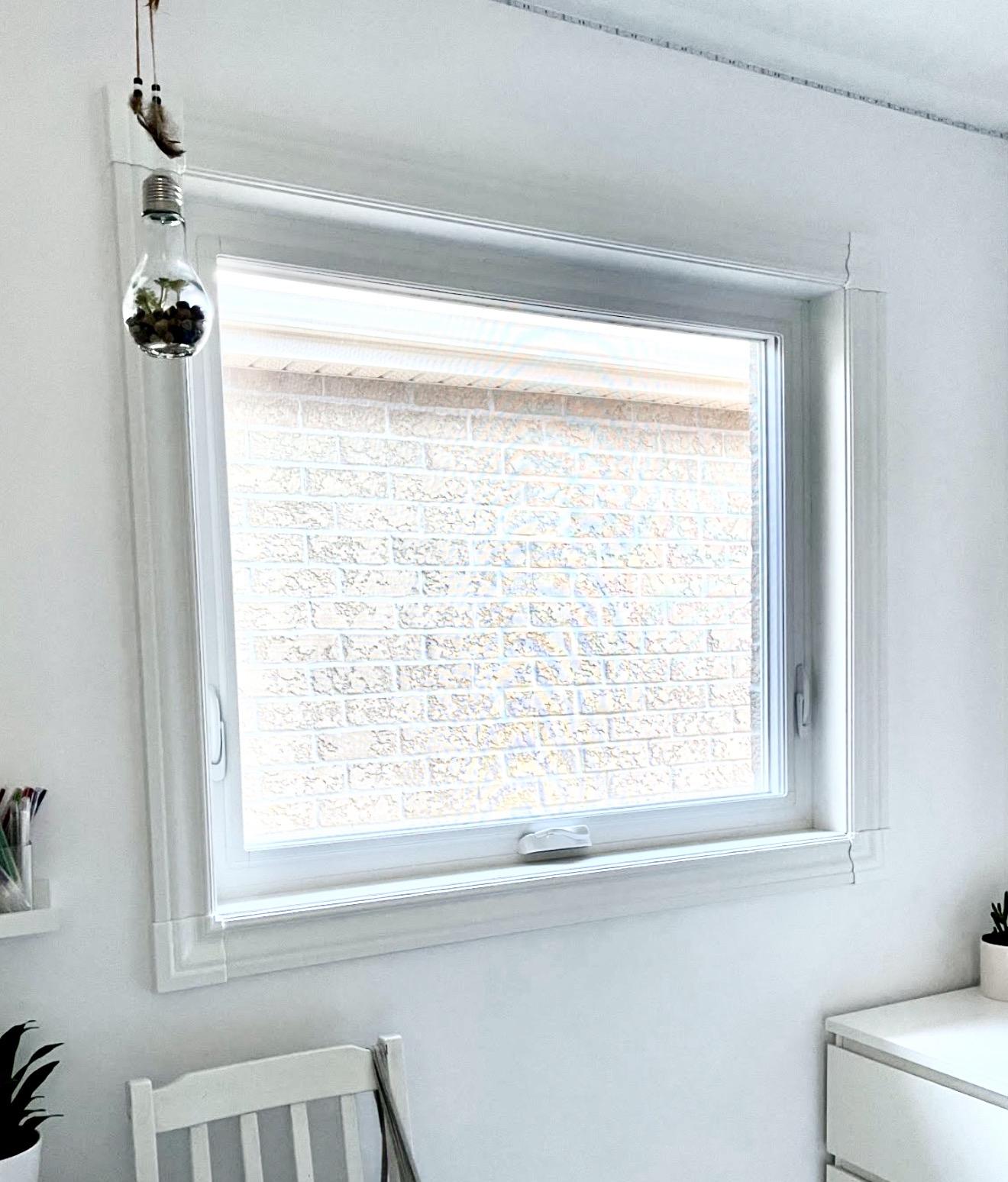 Colonial window casing with 45-degree corner rosettes framing a white casement window, Ontario home interior