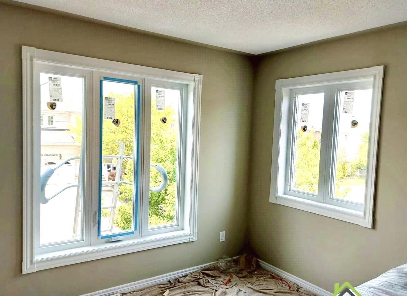 Colonial white window casing with 45-degree rosettes installed on beige-wall bedroom windows, Ontario home