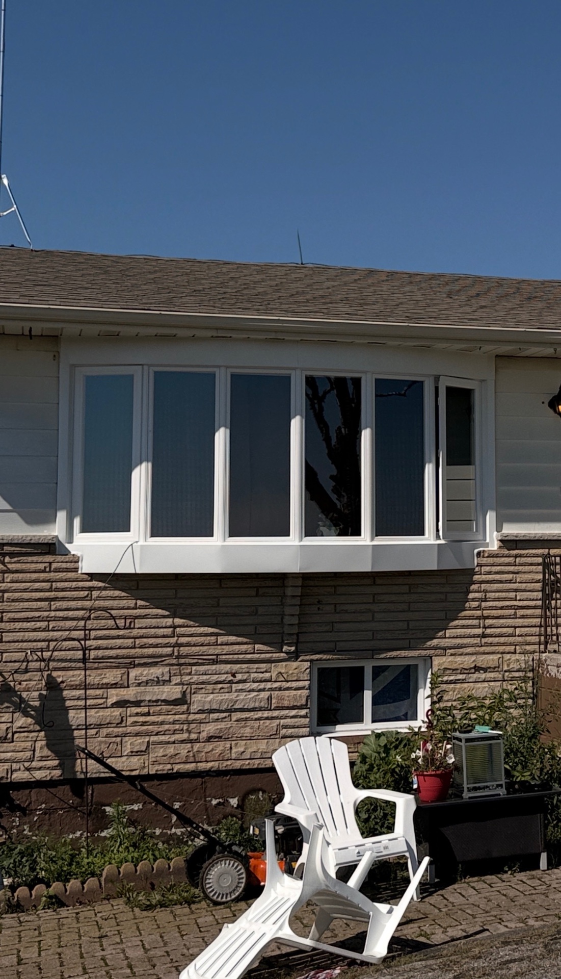 Finished white vinyl six-section bow window on the Brantford home exterior