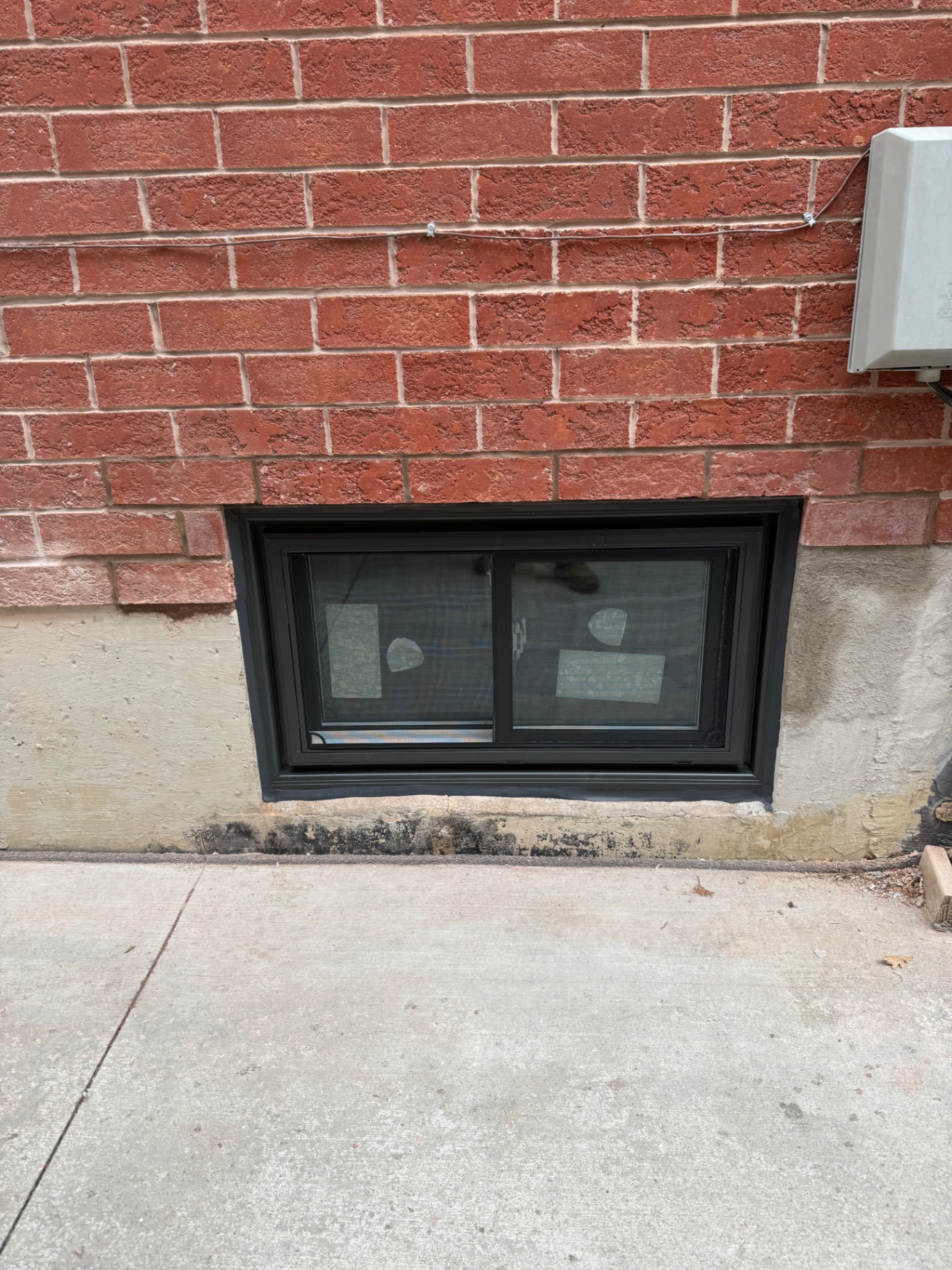 New black vinyl slider basement window installed to replace a rotted wood frame in Vaughan, Ontario