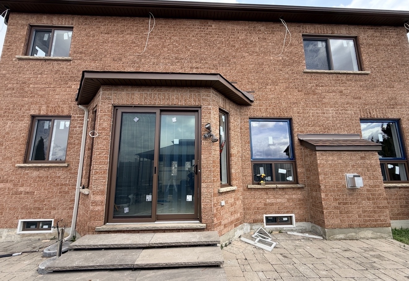 Barrie home exterior showing a brown sliding patio door beside a brown bay window after a full Trust Build installation