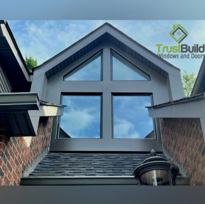 Black gable-top picture window with cross-transom on a grey siding and brick Ontario home by Trust Build