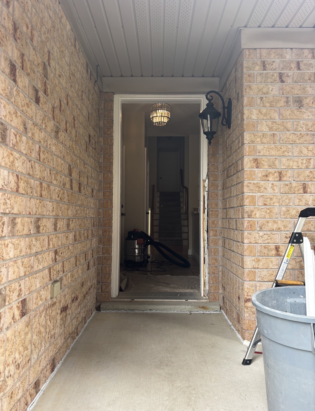 During — the original door and frame fully removed, exposing the rough opening down to the structure, prepared for the new door system