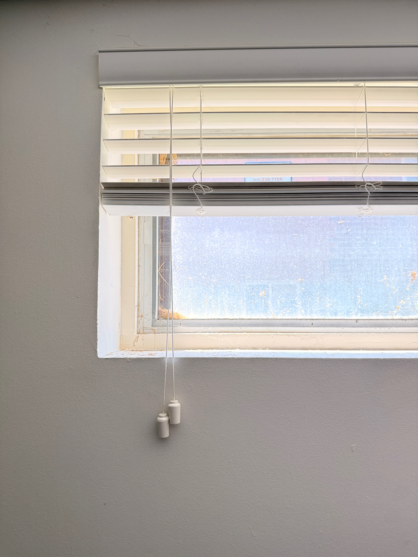 Before photo of the original aluminum window in North York, showing condensation between the panes and a damaged drywall interior ledge