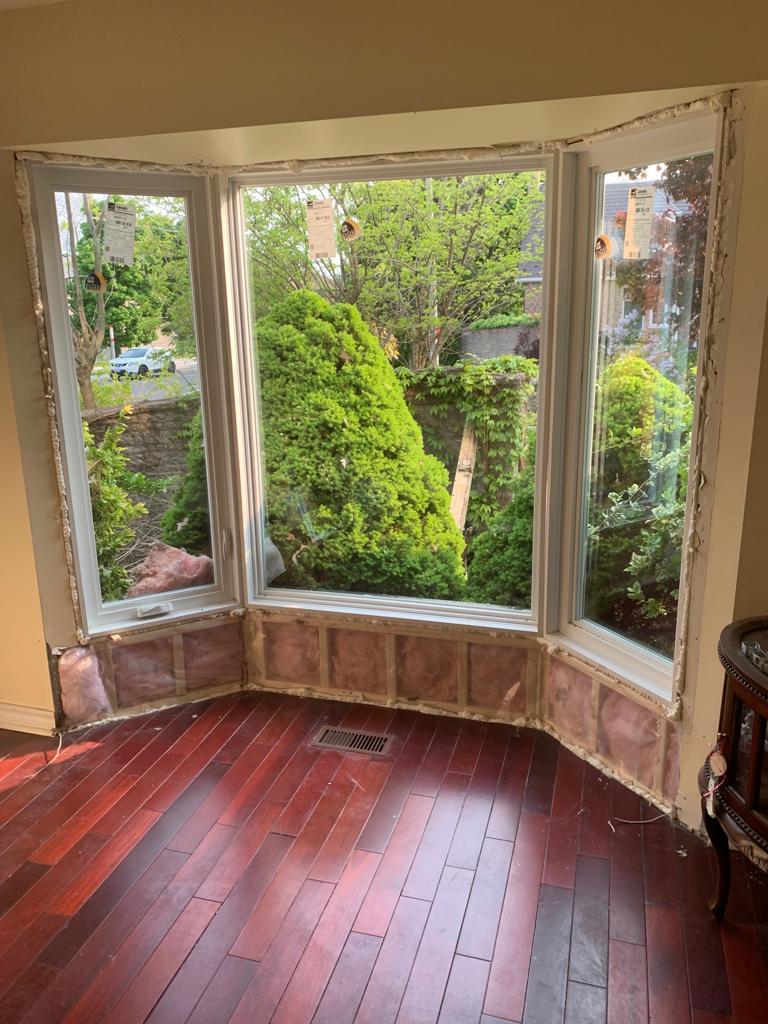Before: old bay window in an Oshawa living room removed for full-frame replacement, showing exposed rough opening and original hardwood floor
